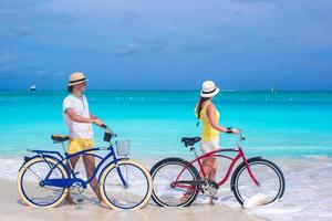 couple avec des vélos sur une plage de sable blanc photo