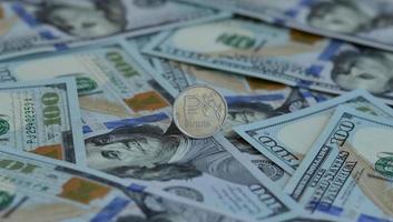notion d'entreprise. taux de change dollar-rouble. pièce de monnaie russe avec emblème et billets de cent dollars américains. photo