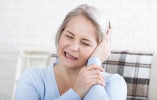 acouphène. gros plan vers le haut profil latéral femme malade ayant des douleurs à l'oreille touchant sa tête douloureuse. photo