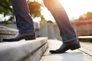 homme d'affaires moderne travaillant les jambes en gros plan en montant les escaliers dans la ville moderne. en heure de pointe pour travailler au bureau pressé photo