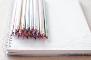 pile de crayons colorés sur un cahier à spirale