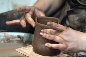 mains lors de la fabrication de détails de poterie en gros plan photo