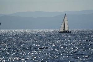 petit voilier sur la mer d'un bleu profond photo
