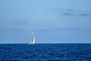 petit voilier sur la mer d'un bleu profond photo