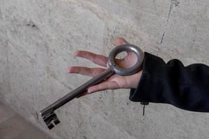 main tenant une clé médiévale en fer géant photo