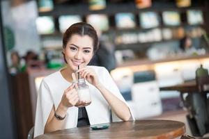 belle femme buvant une boisson sucrée au café photo