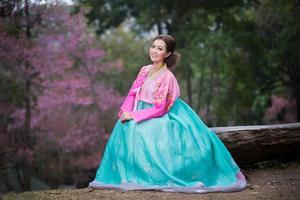 hanbok, la robe coréenne traditionnelle et belle fille asiatique avec sakura photo