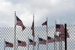 agitant des drapeaux américains derrière la grille de clôture photo