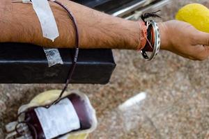 donneur de sang au camp de don de sang tenu avec une balle gonflable tenant dans la main au temple balaji, vivek vihar, delhi, inde, image pour la journée mondiale du don de sang le 14 juin de chaque année, camp de don de sang photo