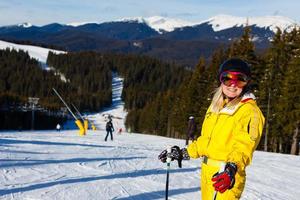 femme skieuse profiter en hiver journée ensoleillée, maison de vacances photo