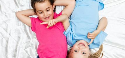 petites filles heureuses allongées sur le dos vue de dessus soeurs photo