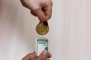bitcoins dorés sur dollars américains entre les mains concept d'échange de monnaie électronique photo