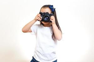fille prenant une photo avec un appareil photo rétro professionnel isolé sur blanc