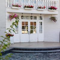 porte d'entrée blanche avec petites fenêtres décoratives carrées et pots de fleurs photo