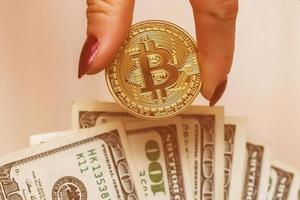 bitcoins dorés sur dollars américains entre les mains concept d'échange de monnaie électronique photo