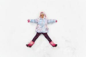 portrait d'une petite fille souriante dans la neige photo