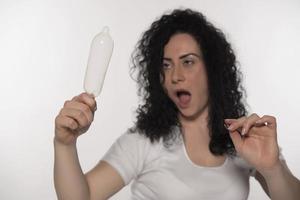 femme tenant un préservatif. enregistrer le concept de sexe. isolé photo