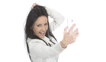 image d'une belle femme brune riant tout en prenant une photo de selfie sur un téléphone portable