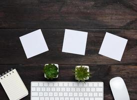 clavier et souris sans fil blancs sur une table en bois marron photo