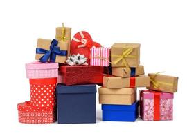 grande pile de cadeaux emballés dans du papier kraft brun et attachés avec un ruban de soie bleu et rouge photo