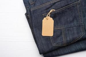 Étiquette rectangulaire marron vierge attachée dans la poche arrière d'un jean plié bleu photo