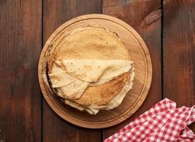 crêpes rondes frites sur une planche de bois, table marron photo