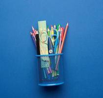 ciseaux en plastique et crayons en bois multicolores sur fond bleu