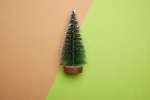 décor de noël arbre vert sur une surface colorée, minimalisme photo