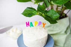 gâteau d'anniversaire, sur un biscuit crémeux l'inscription bonheur. concept de vacances et d'anniversaire surprise. photo