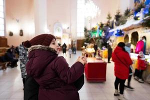 mère avec sa fille regardant la crèche de noël à l'église. photo