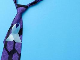 cravate en soie violette pour hommes et ruban bleu plié en boucle sur fond bleu photo