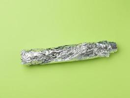 rouleau de papier d'aluminium gris pour la cuisson et l'emballage des aliments sur fond vert, photo