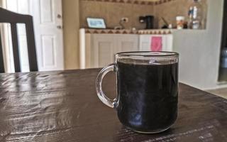 tasse en verre de café noir du Mexique sur fond de bois. photo