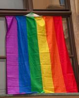 fierté du drapeau arc-en-ciel lgbt dans la ville de bratislava. vue de la fenêtre d'un immeuble avec un drapeau arc-en-ciel. photo