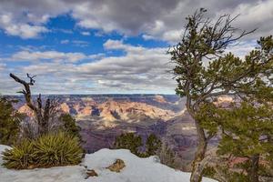 vue panoramique depuis la falaise sud du grand canyon avec des formations nuageuses spectaculaires en hiver photo
