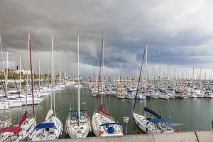 photo de bateaux dans la marina de barcelone devant des nuages menaçants