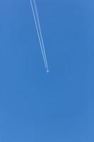 avion bimoteur pendant le vol en haute altitude avec traînées de condensation photo