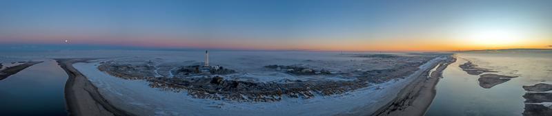 panorama de drone sur la plage et le phare de la station balnéaire danoise de blavand au lever du soleil photo