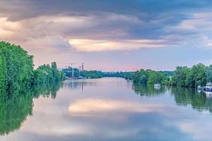 photo de la ligne d'horizon de francfort-sur-le-main prise à une grande distance de l'écluse principale d'eddersheim dans la soirée d'incandescence