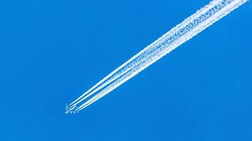 avion à quatre moteurs pendant le vol en haute altitude avec des traînées de condensation photo