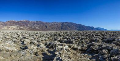 Vue sur la surface fissurée du parcours de golf des diables dans la vallée de la mort en hiver photo