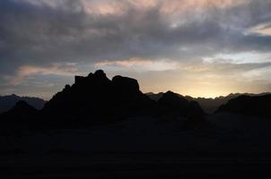 sommets des montagnes dans le désert contre le coucher du soleil photo