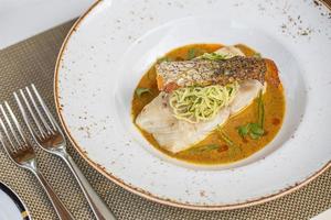 filet de saumon grillé accompagné de légumes et d'un verre de vin blanc. assiette de luxe, plat gastronomique photo