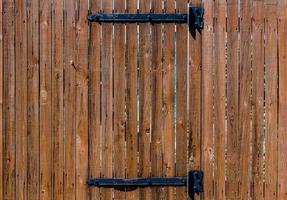 clôture en bois de texture avec une porte en bois sur des charnières en fer photo