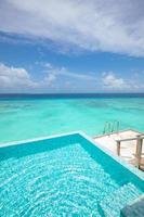 profitez de la piscine à débordement avec vue sur l'océan en vacances. scène de rêve, piscine sans fin dans une mer bleue azur tropicale parfaite. paysage d'été incroyable dans un hôtel de luxe. paysage exotique photo