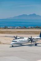 05.13.19 - santorin, grèce olympic airlines atterrissant. à l'aéroport international de l'île de santorin, grèce. olympic air bombardier dash taxi sur piste avec belle vue sur la mer photo