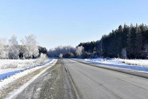 une route à grande vitesse dans un champ enneigé. route enneigée en hiver. photo