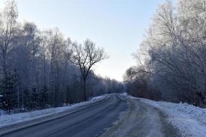 une route à grande vitesse dans un champ enneigé. route enneigée en hiver. photo