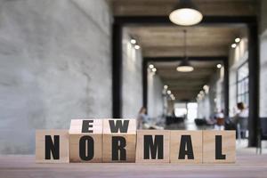 cubes de blocs de bois renversant pour un nouveau mot normal pour changer le nouveau mode de vie ou les affaires et l'économie après la pandémie de coronavirus photo