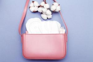 tampons, protège-slips hygiéniques, serviettes hygiéniques féminines dans un sac cosmétique rose pour femme photo